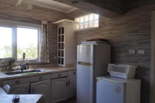 a kitchen with a white refrigerator and a sink at Spacious Beach Vacation House in El Alamein