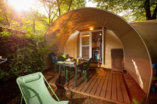 une tente dôme avec une table et des chaises dans une cour arrière dans l'établissement Camping des Drouilhèdes, à Peyremale
