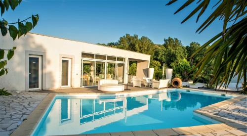 une piscine devant une maison dans l'établissement Mas Chansonnet Gites et Chambres d'hotes de charme, à Les Fumades-Les Bains