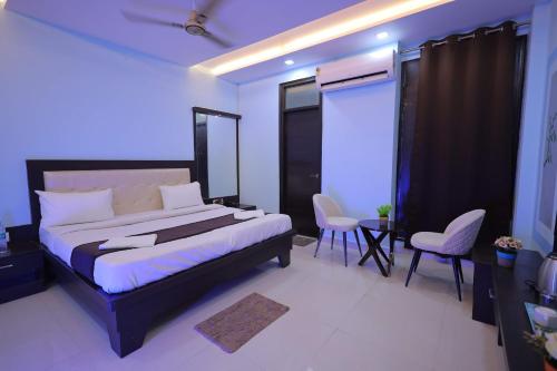 a bedroom with a large bed and two chairs at SHAKTI VILLA HOME STAY in Agra