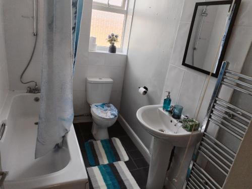 y baño con aseo, lavabo y ducha. en Comfortable 4-Bed House in Hucknall Nottingham, en Nottingham