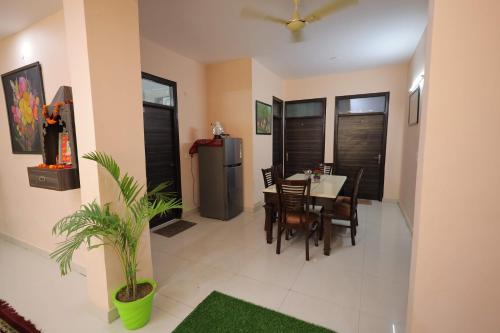 a dining room with a table and a refrigerator at SHAKTI VILLA HOME STAY in Agra