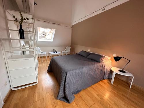 メスにあるAppartement des Vignesのベッドルーム1室(ベッド1台、テーブル、椅子付)