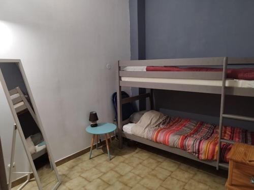 Zimmer mit 2 Etagenbetten und einem kleinen Tisch in der Unterkunft Pavillon les pieds dans l'eau in Valras-Plage