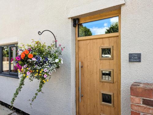 uma porta com um ramo de flores à frente em The Cob House. em Ifton Heath