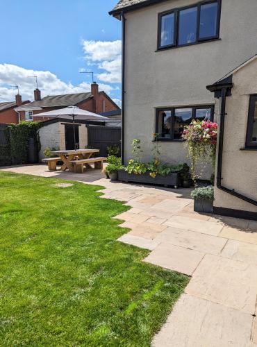 a house with a patio and a picnic table at The Cob House. in Ifton Heath