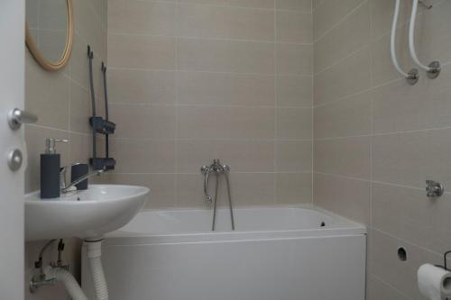 a bathroom with a bath tub and a sink at City Center Condo Vranje in Vranje