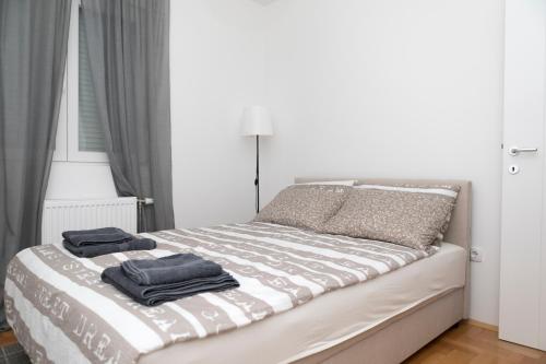 a bedroom with a bed with two towels on it at City Center Condo Vranje in Vranje