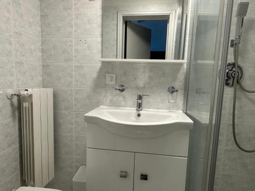 a white bathroom with a sink and a shower at Duomo Appartamento in Massa Marittima