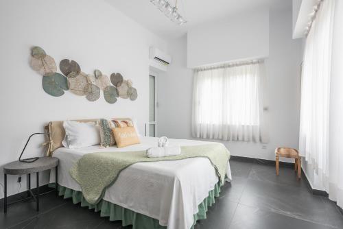 a white bedroom with a bed and a window at Garden Villa Glyfada in Athens