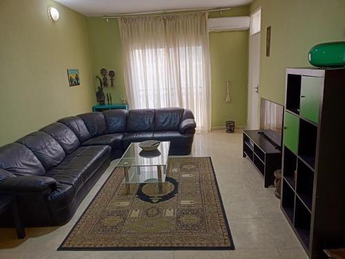 a living room with a leather couch and a table at Appartement 2 chambres Yoff Virage Dakar Senegal in Dakar