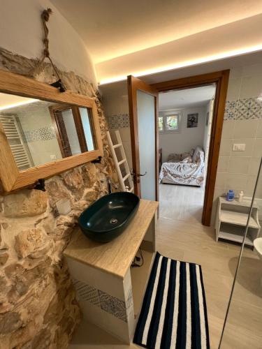 a bathroom with a sink on a stone wall at Trulli delle succulente in Capilungo