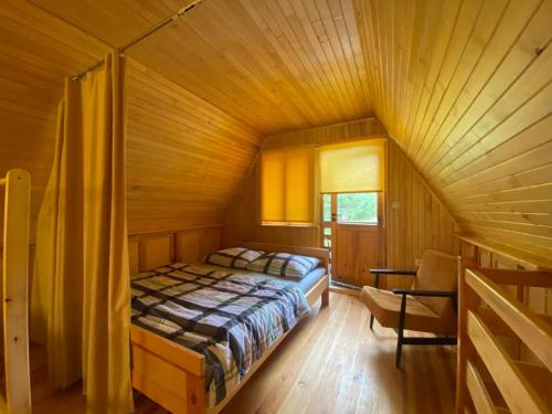 a bedroom with a bed in a wooden room at Jaś Roztocze in Nielisz