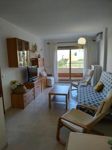 - un salon avec un canapé et une télévision dans l'établissement Apartamento en Playa de Gandia con piscina, à Gandía