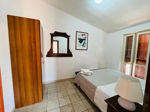 1 dormitorio con cama, mesa y espejo en Villa Grazia, en Capo Vaticano