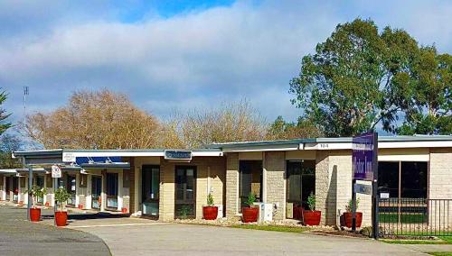 a gas station with potted plants in front of it at Central Highlands Motor Inn in Kyneton