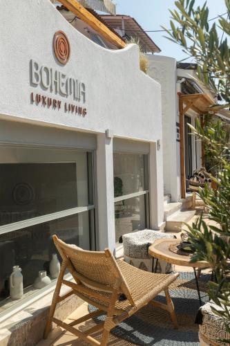 a wicker chair sitting in front of a building at Bohemia Luxury Living in Hanioti