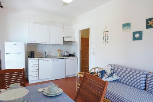a kitchen with white cabinets and a table in a kitchen at Case vacanza Barbatoja in Fetovaia