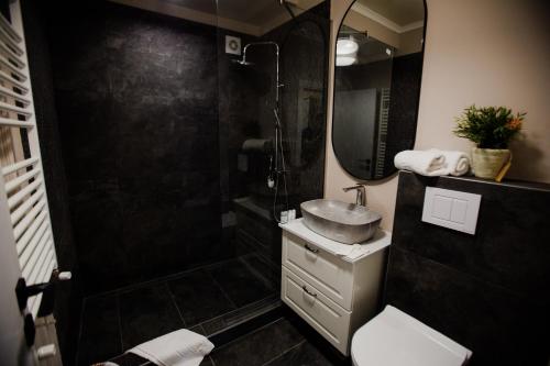 a bathroom with a shower and a sink and a mirror at AVANGARDE SEA Luxury Apartments in Mamaia Nord