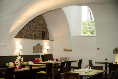 ein Esszimmer mit Tischen, Stühlen und einem Fenster in der Unterkunft Hotel Residenz am Königsplatz in Speyer