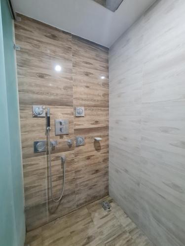 a bathroom with a shower with a wooden wall at Srina Forest Roar, Corbett- Near Pick up point in Rāmnagar
