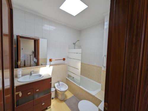 een badkamer met een wastafel, een toilet en een bad bij Dúplex Calle Cuba Gijón in Gijón