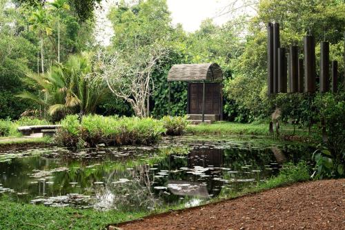 a garden with a pond and a gazebo at Lunuganga Estate in Bentota