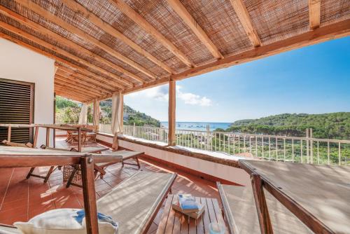 a room with a balcony with a view of the ocean at Case vacanza Barbatoja in Fetovaia