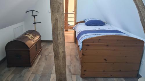 - une chambre avec un lit en bois et une commode en bois dans l'établissement Clos Marie-Louise, à Offranville