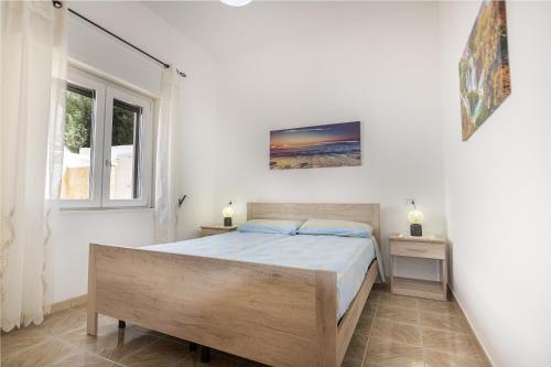 a white bedroom with a bed and a window at Residence Dolce Vita in Torre Lapillo