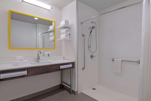 een badkamer met een wastafel en een douche bij Hampton Inn & Suites Stamford in Stamford