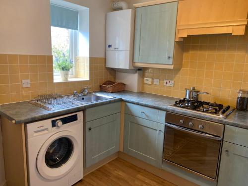 a kitchen with a washing machine and a sink at Idillic Two bed country cottage in Kirkby Thore