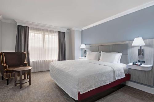 a hotel room with a bed and a chair at Hampton Inn & Suites Stamford in Stamford