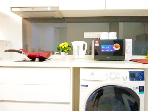 a kitchen with a washing machine and a microwave at Medini Elysia Park , 3 min to Legoland, Netflix By Hint Homestay in Nusajaya
