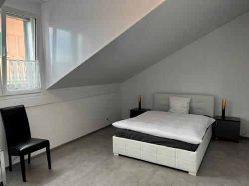 a white bedroom with a bed and a chair at Hotel Hippel Krone in Kerzers
