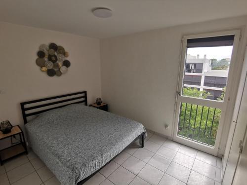 a bedroom with a bed and a large window at Appartement refait à neuf, climatisé avec vue mer et montagne, avec place de parking privative in Saint-Cyprien