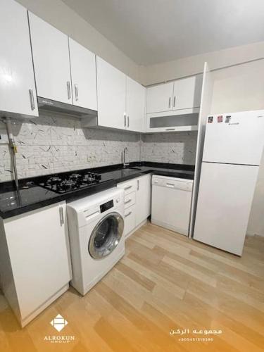 a kitchen with white cabinets and a washing machine at شقة مركزية بإطلالة ساحرة in Istanbul