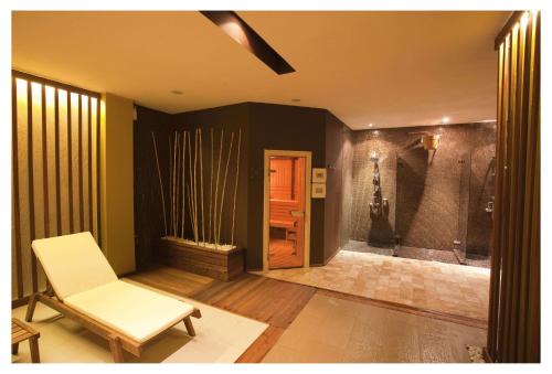 a living room with a white chair and a door at Aparthotel Regina Mare in Tsarevo