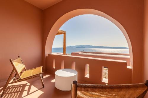 an arched window in a room with a view of the ocean at Akre Hotel in Naxos Chora