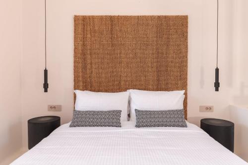 a bedroom with a white bed with two pillows at Akre Hotel - Designed for Adults in Naxos Chora