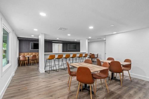 オーランドにあるSuper 8 by Wyndham Kissimmee-Orlandoのダイニングルーム(テーブル、椅子付)、バー