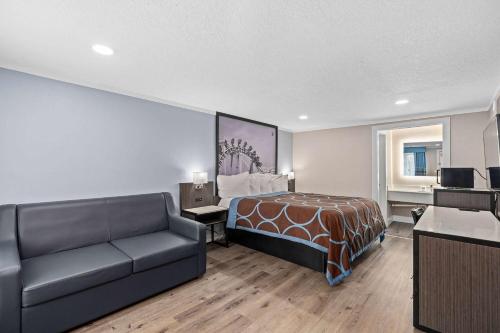 um quarto de hotel com uma cama e um sofá em Super 8 by Wyndham Kissimmee-Orlando em Orlando