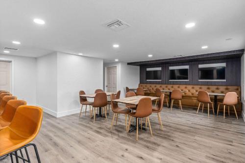 a waiting room with tables and chairs in a building at Travelodge by Wyndham Kissimmee Orlando in Orlando
