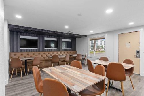 a meeting room with tables and chairs and a tv at Travelodge by Wyndham Kissimmee Orlando in Orlando