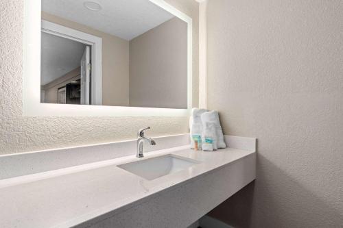 a bathroom with a sink and a mirror at Travelodge by Wyndham Kissimmee Orlando in Orlando
