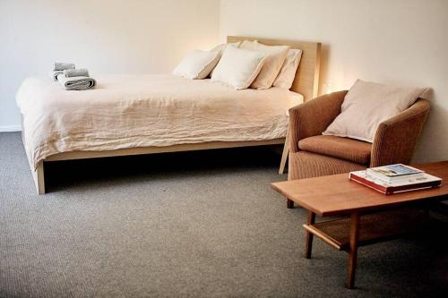 um quarto com uma cama, um sofá e uma mesa em Cosy hillside studio em Ocean Shores