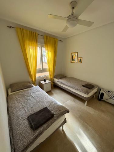 um quarto com 2 camas e uma janela em Sea view apartment 2 BR costa blanca em Orihuela