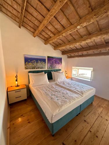 een slaapkamer met een bed en een houten vloer bij Apartment Luka in Rovinj