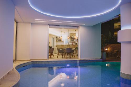 a house with a swimming pool and a dining room at Theo Beach Hotel Apartments in Rethymno Town