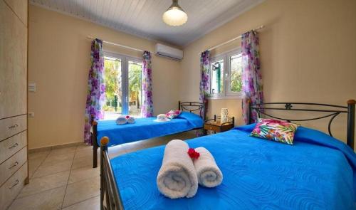 Dos camas en un dormitorio con toallas. en Villa Esperanza by Imagine Lefkada, en Lefkada